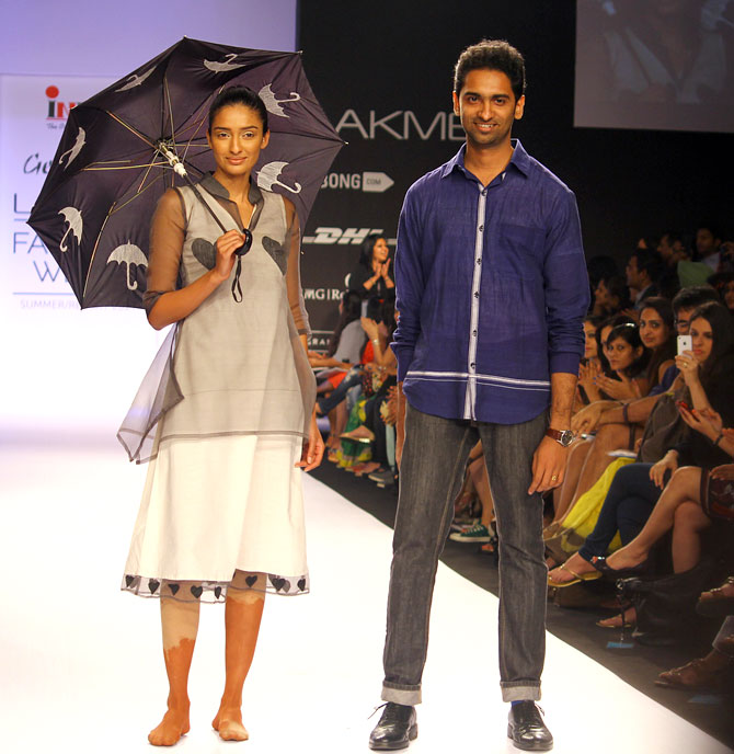 Sreejith Jeevan poses next to a model wearing his creation