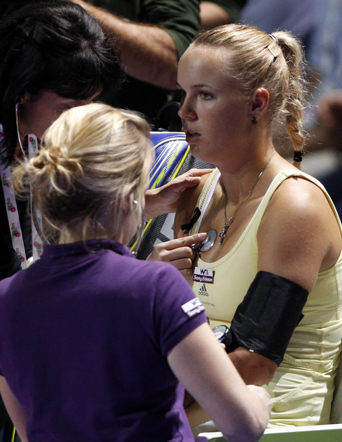Caroline Wozniacki of Denmark have her blood pressure checked by a doctor during her WTA tennis championships match against Petra Kvitova of the Czech Republic in Istanbul, October 27, 2011.