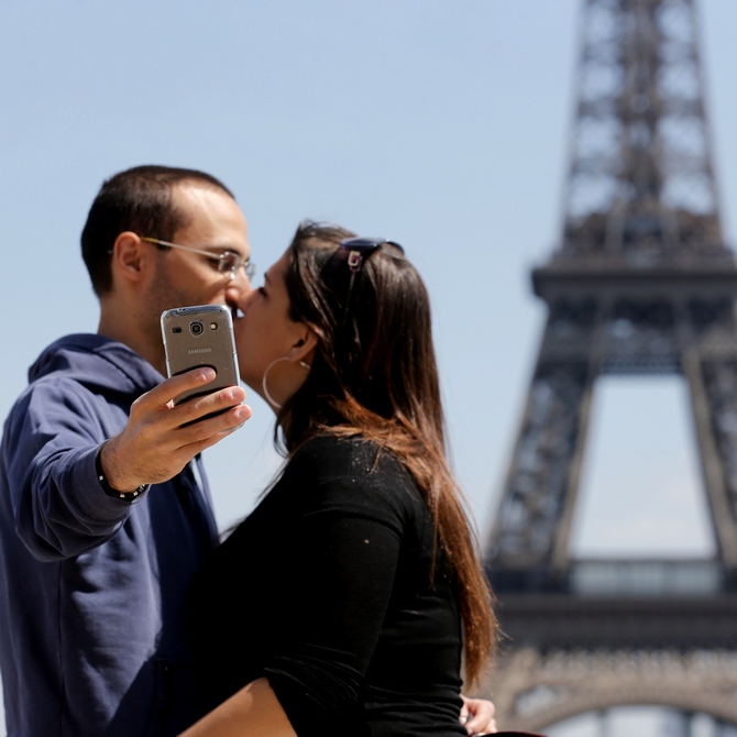 A couple takes a selfie before the Eiffel Tower in Paris 