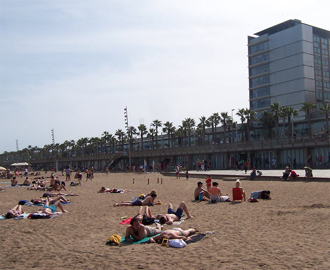 Sunbathers relax along the Barceloneta Beach in Barcelona.