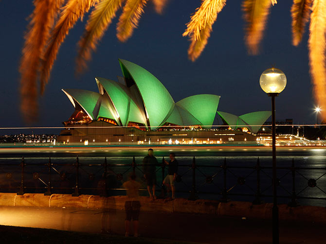 Tourists take pictures in this long exposure photograph as the Sydney Opera House is lit with green lights during St Patrick's Day celebrations in central Sydney.
