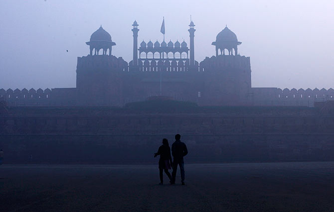 A couple walks in front of the historic Red Fort in New Delhi.