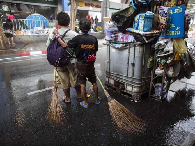If unclean streets and coups don't bother you much, Bangkok is the place to go! :-P Anti-government protesters pause as they clean a street in Bangkok's shopping district. (Picture used here for representational purposes only.)