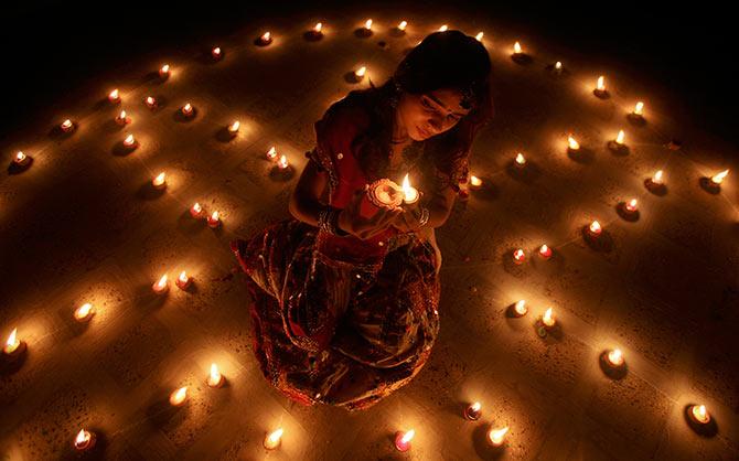 A woman lights an earthen lamp during the celebrations on the eve of Diwali.