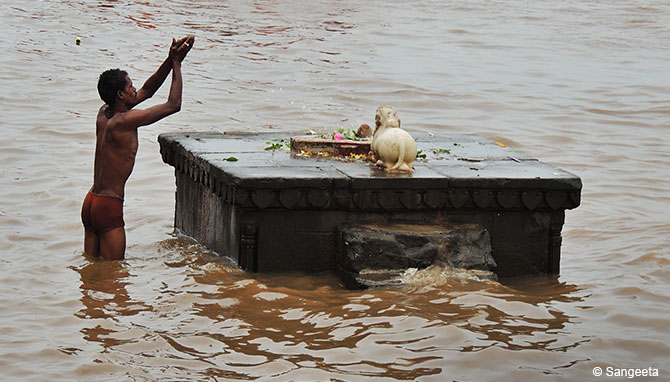 A man performing puja on the ghats at Maheshwar