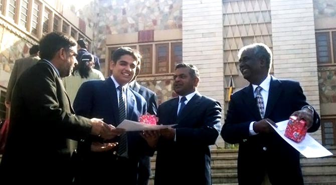 Gaurav receiving a prize in school when he was 17 while his father (left) looks on.