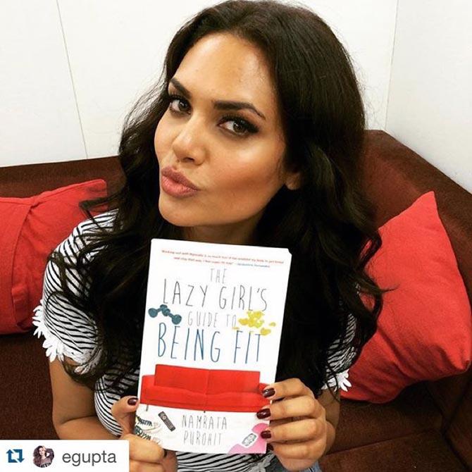 Esha Gupta holds up a copy of Purohit's latest book