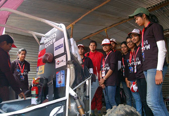 Saachi Khandekar (in the red suit) with her team-mates as they work on their vehicle. The vehicle had broken down, but their spirits were intact;