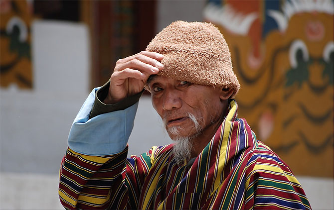 A local in Bhutan shields himself from the sun.