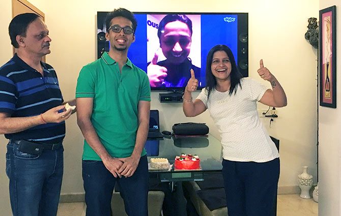 Chirag is flanked by his parents while his sister congratulates him over Skype.