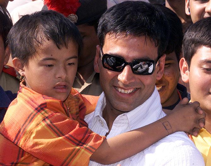 A mentally retarded child hugs actor Akshay Kumar