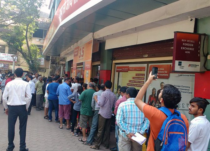 People queue up for money outside a Mumbai bank