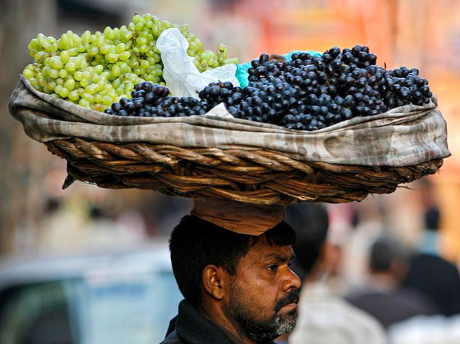 A hawker carries grapes in a basket on his head in the old quarter of Delhi, December 18, 2006. Photograph: Ahmad Masood/Reuters