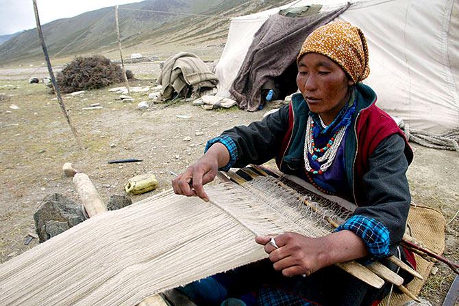 A nomad woman weaves pashmina at Taglang La in Ladakh