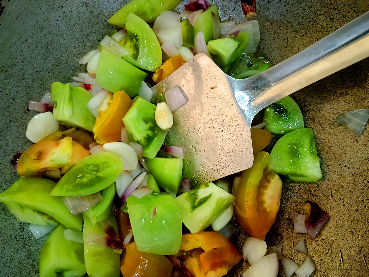 Cooking green tomatoes with onion and garlic for the chutney