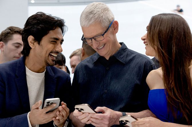 CEO of Apple Tim Cook looks at the new iPhone 16 with Siddharth Suryanarayan and Aditi Rao Hydari