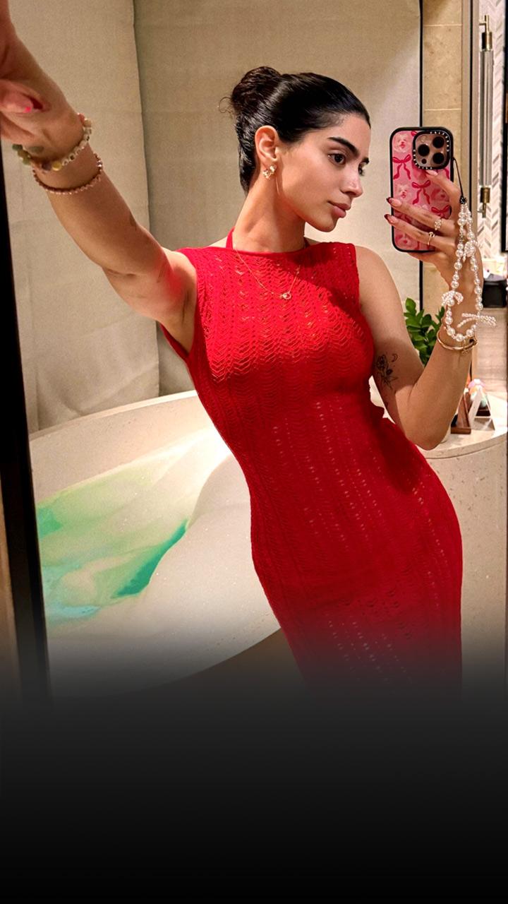 Khushi Kapoor is wearing a red crochet dress; her hair is in a top knot.
