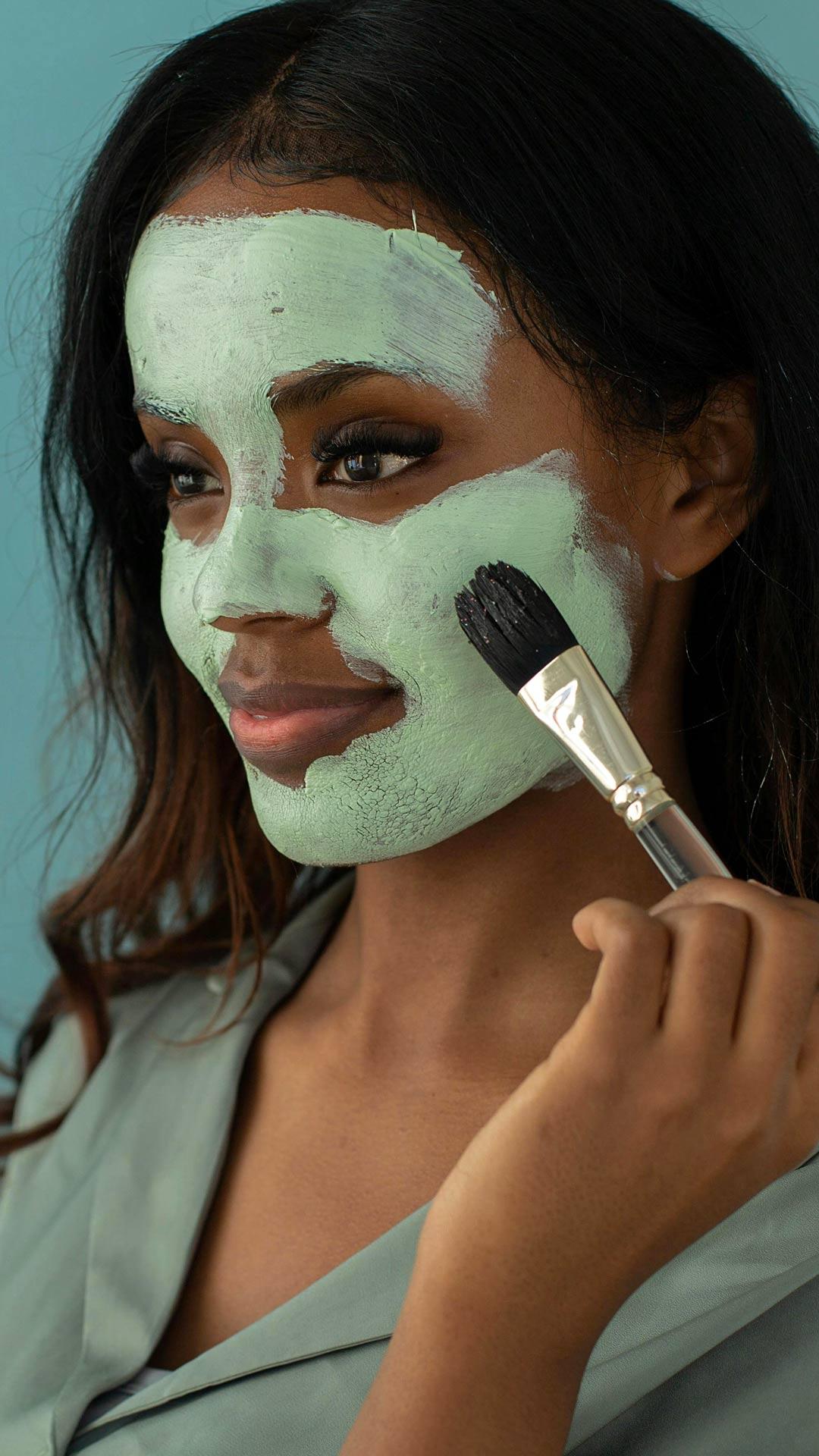 Woman Putting on Facial Cream with a Brush