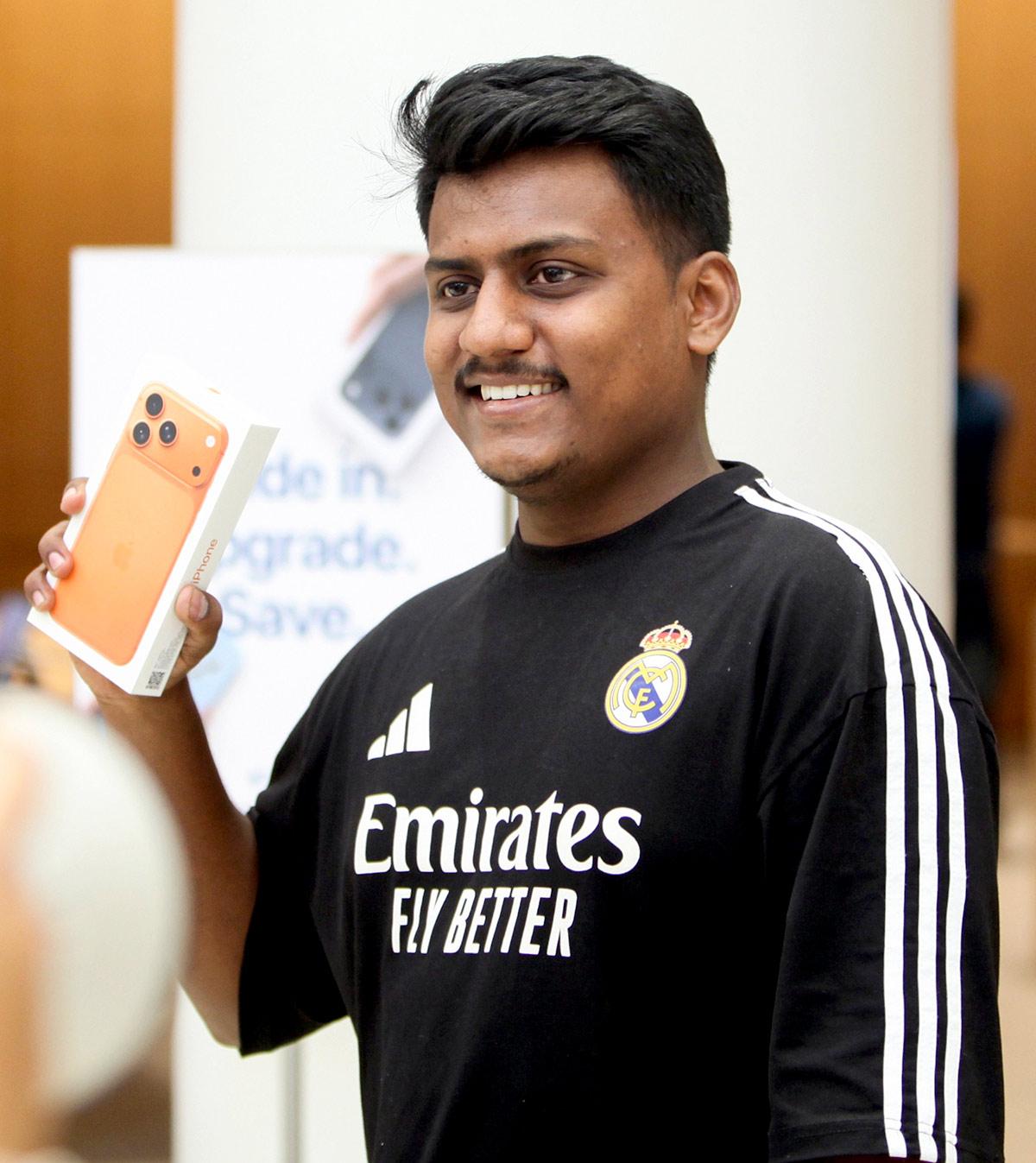 A boy poses with the newly launched iPhone 17 at the Apple Store