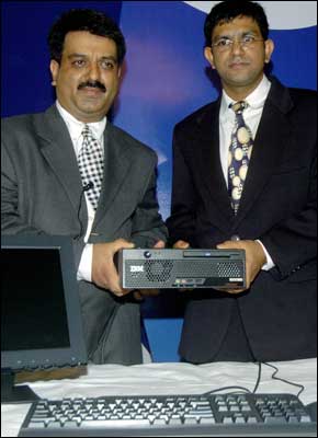 Neeraj Sharma (L), vice-president of the personal computing division, IBM India, and Rahul Agarwal (R), brands manger (desktops), IBM India, hold the world's smallest desktop S50 Ultra during an unveiling function in New Delhi on Monday. Photo: Raveendran / AFP / 