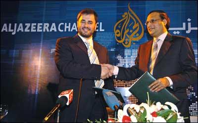 Managing Director for Qatar-based television channel Al Jazeera Wadah Khanfar (L) with Chairman of India TV Rajat Sharma (R) looks on after signing a bulletin sharing agreement in New Delhi on Thursday. Photo: Prakash Singh/AFP/Getty