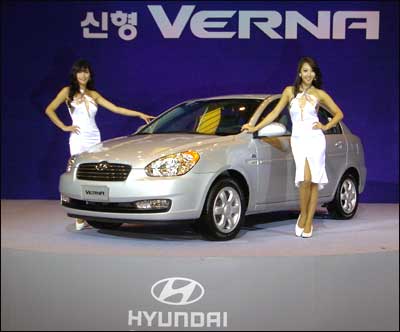 South Korean models pose next to Hyundai Motors' new offerig, Verna, at its unveiling ceremony in Seoul last month. Hyundai has priced the car from $8,302 to $14,290 for the Korean market. Photograph: Kim Jae-Hwan/AFP/Getty Images