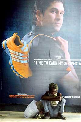A homeless man sits in front of a closed shoe-shop emblazoned with an advertisement featuring star Indian cricketer Sachin Tendulkar during the 72-hour traders' strike in New Delhi. Photograph: Raveendran / AFP / Getty Images