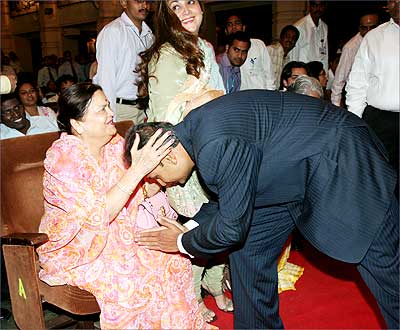 Anil Ambani seeks the blessings of his mother, Kokilaben, at the AGM of Reliance Communications Ltd in Mumbai on Tuesday. Also seen in the picture is Anil's wife Tina Ambani (center). Photograph, courtesy: Reliance Communications Ltd.