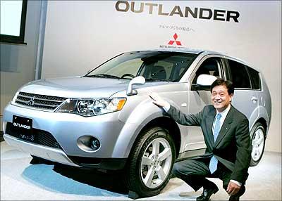 Image: Mitsubishi Motors Corp. president Osamu Masuko with the sports utility vehicle Outlander. | Photograph: Kazuhiro Nogi/AFP/Getty Images