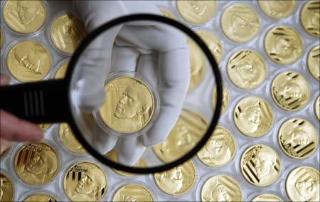 A worker checks the quality of a commemorative gold medal with the face of US President Barack Obama