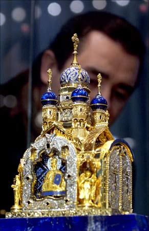 A visitor inspects a gold-and-jewel replica of a Russian Orthodox Church made by Russian artists.
