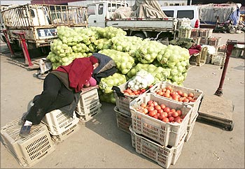 A vegetable vendor rests while waiting for customers at a wholesale market in Taiyuan, China.