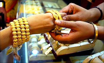 A woman wears gold bangles at a jewellery shop in Allahabad.