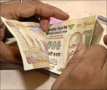 A bank teller counts Rs 500 notes.