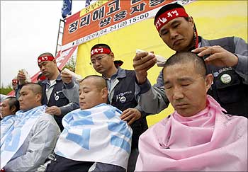 Labour union workers of Ssangyong Motor under court receivership, have their hair shaved to show their will and determination during a rally against the layoff plan of the company.