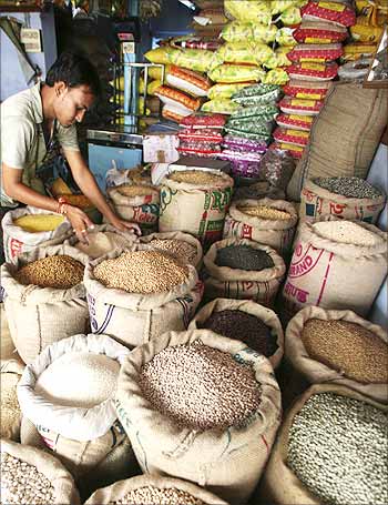 A vendor arranges sacks of cereals at his grocery shop.