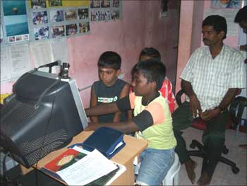 Children fiddle with the computer at one of the Foundation centres.