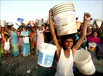 Slum dwellers shout slogans as they carry empty containers during a protest in Chandigarh.