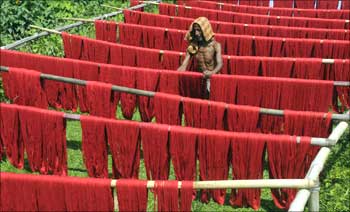 A worker dries thread for weaving handlooms at a textile mill in Agartala, Tripura.