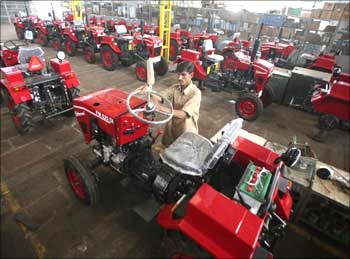A technician fits a steering wheel on a 12-horsepower mini-tractor inside a manufacturing unit of P.M. Diesels in Rajkot.