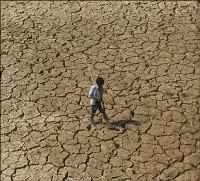 A man walks across a parched piece of land