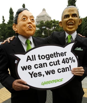 Greenpeace activists wearing masks depicting Japan's Prime Minister Hatoyama and US President Obama.