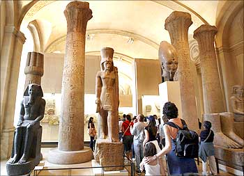 Visitors walk in the Egyptian gallery of the Louvre Museum in Paris.