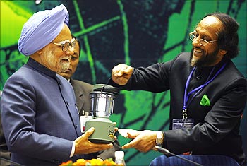 Rajendra Pachauri presents a solar chargeable torch to Prime Minister Manmohan Singh.