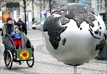 A woman rides a bicycle past a globe in downtown Copenhagen during Copenhagen climate meet in 2009.