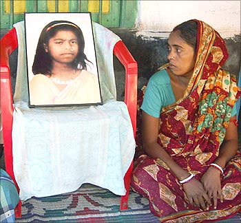 Mother of 18-year-old girl Tapasi Malik, looks at a photograph of her.