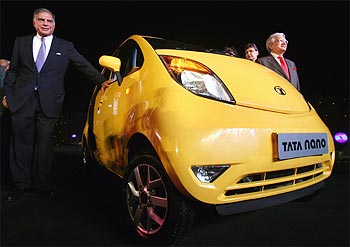 Tata Motors chairman Ratan Tata (left) poses with Nano car.