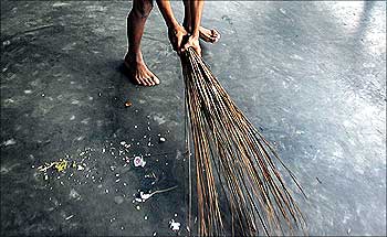 A child sweeps the floor at a rescue home.
