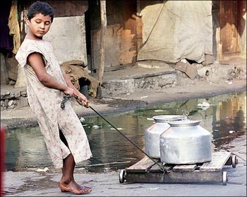 A child pulls a cart with water-filled bowls in it.