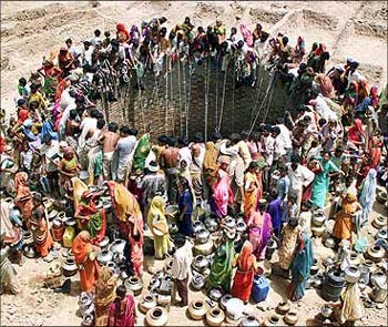 Rural women gather at a well to collect water.